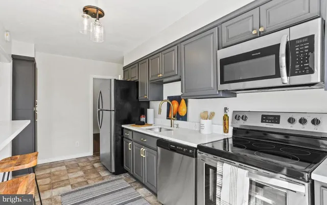 a kitchen with stainless steel appliances granite countertop a stove refrigerator and microwave