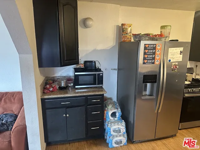 a kitchen with stainless steel appliances granite countertop a refrigerator and a stove