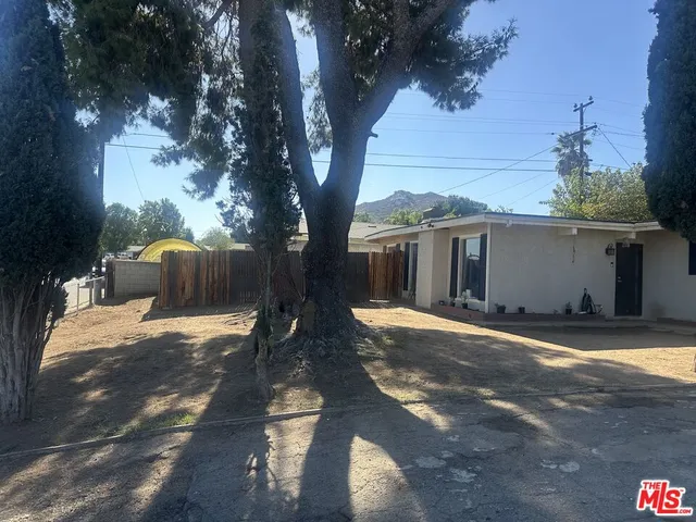 a view of a house with backyard and a tree