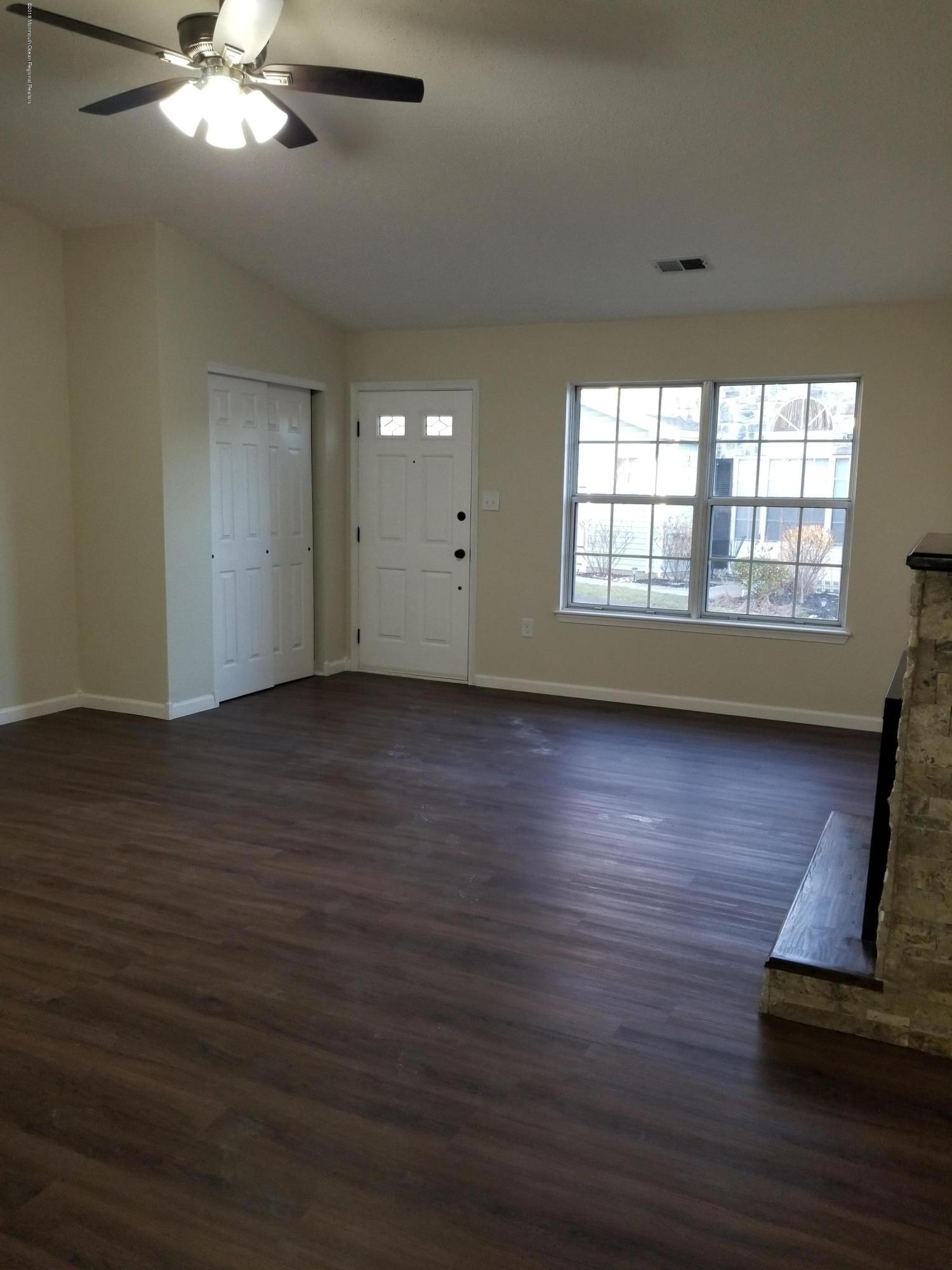 33 Ivy Ridge Close, Unit 1000 Freehold, NJ 07728 - Photo 13 of 31 a view of an empty room with wooden floor and a window