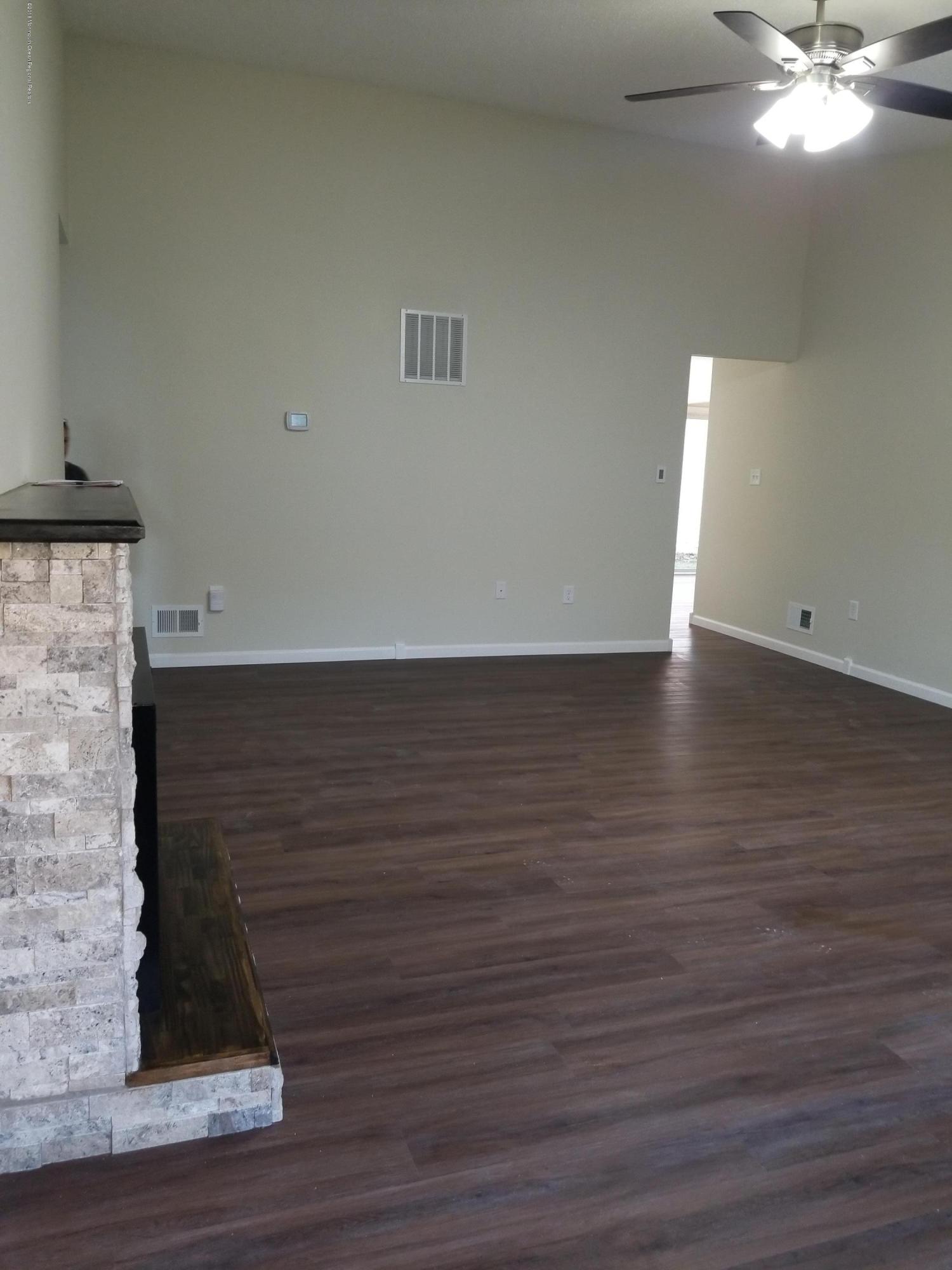 33 Ivy Ridge Close, Unit 1000 Freehold, NJ 07728 - Photo 15 of 31 a view of an empty room with wooden floor and a ceiling fan