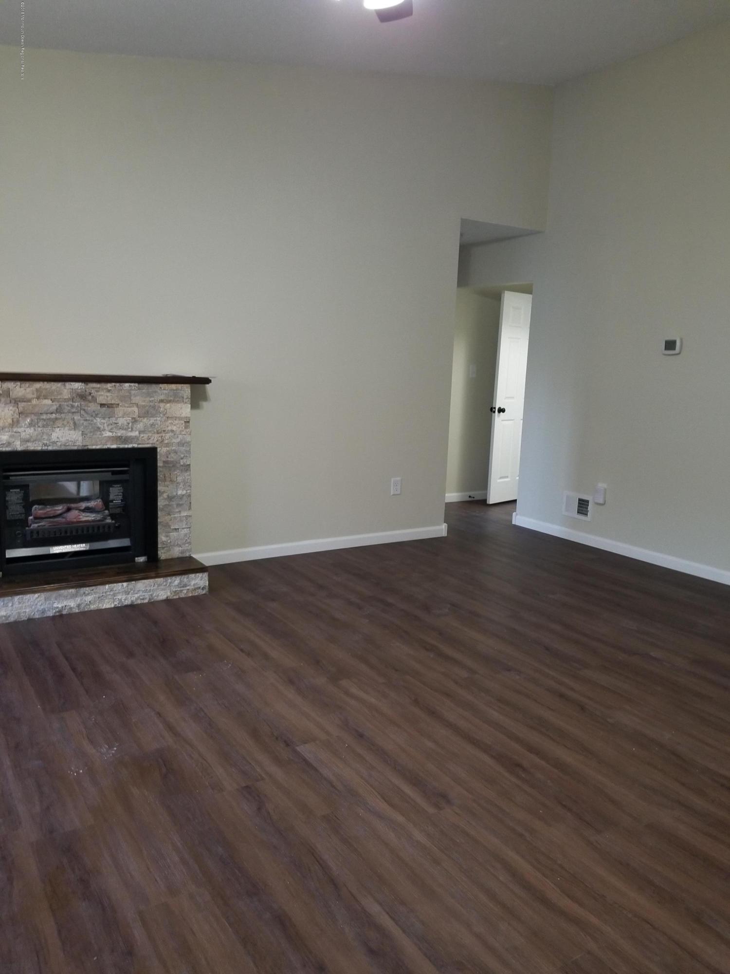 33 Ivy Ridge Close, Unit 1000 Freehold, NJ 07728 - Photo 17 of 31 a view of an empty room with wooden floor fireplace and a window