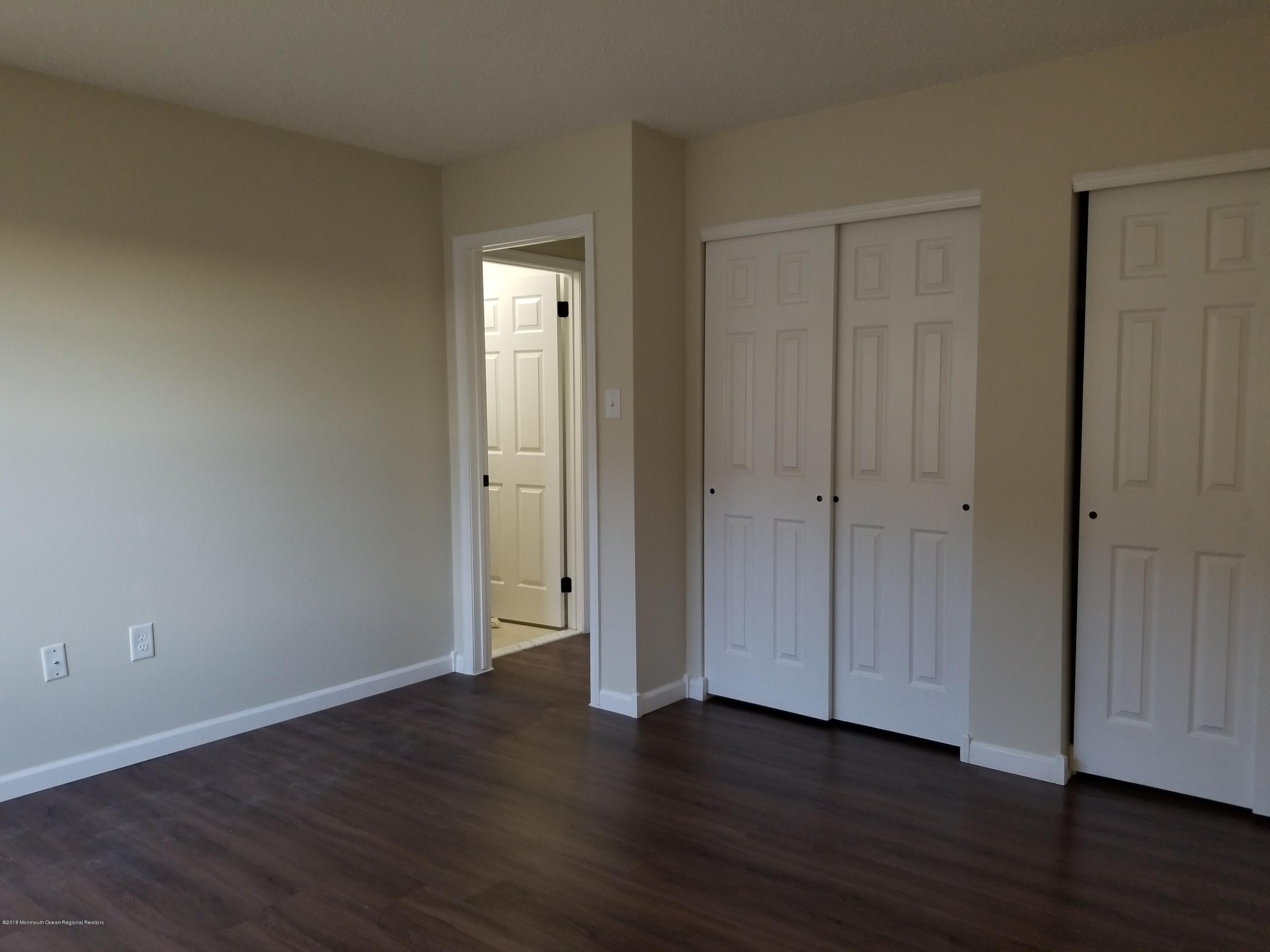 33 Ivy Ridge Close, Unit 1000 Freehold, NJ 07728 - Photo 21 of 31 a view of an empty room with wooden floor