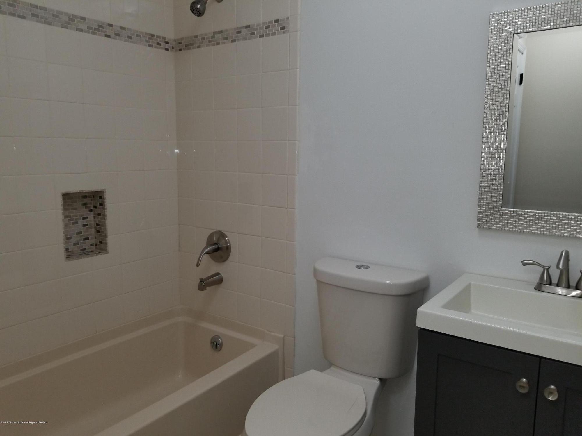 33 Ivy Ridge Close, Unit 1000 Freehold, NJ 07728 - Photo 28 of 31 a bathroom with a sink mirror vanity and toilet