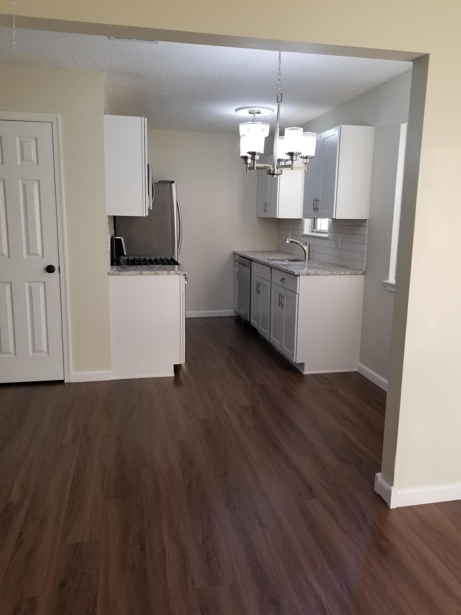 33 Ivy Ridge Close, Unit 1000 Freehold, NJ 07728 - Photo 3 of 31 a view of kitchen with granite countertop cabinets and wooden floor