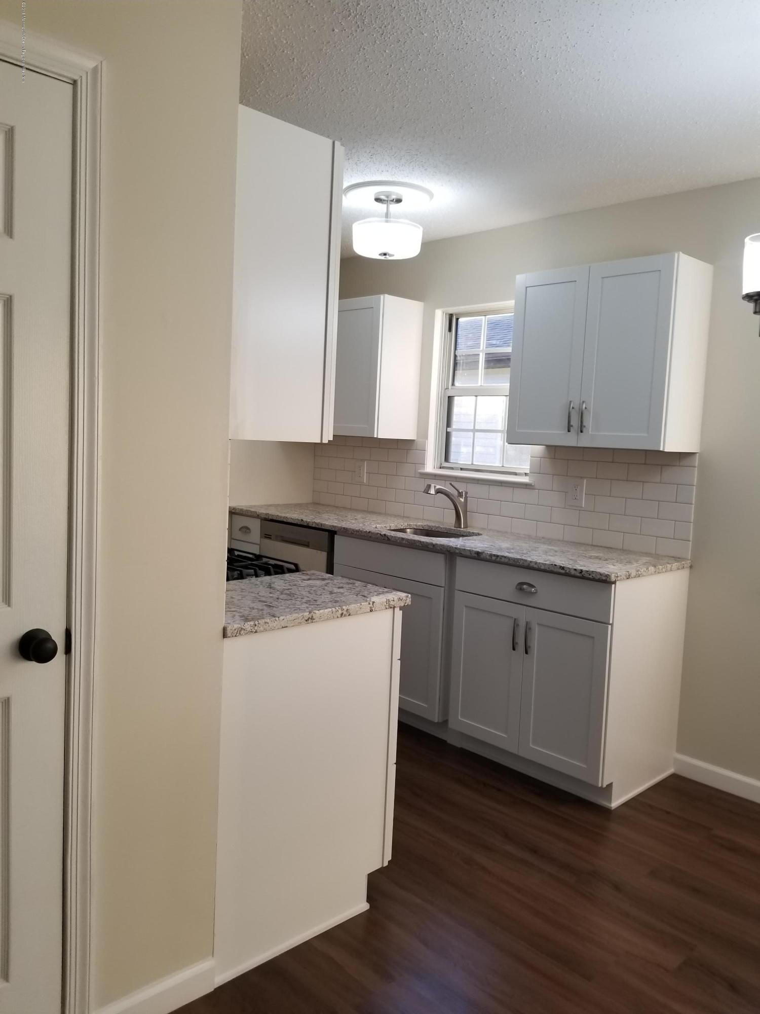 33 Ivy Ridge Close, Unit 1000 Freehold, NJ 07728 - Photo 7 of 31 a kitchen with a sink cabinets and wooden floor