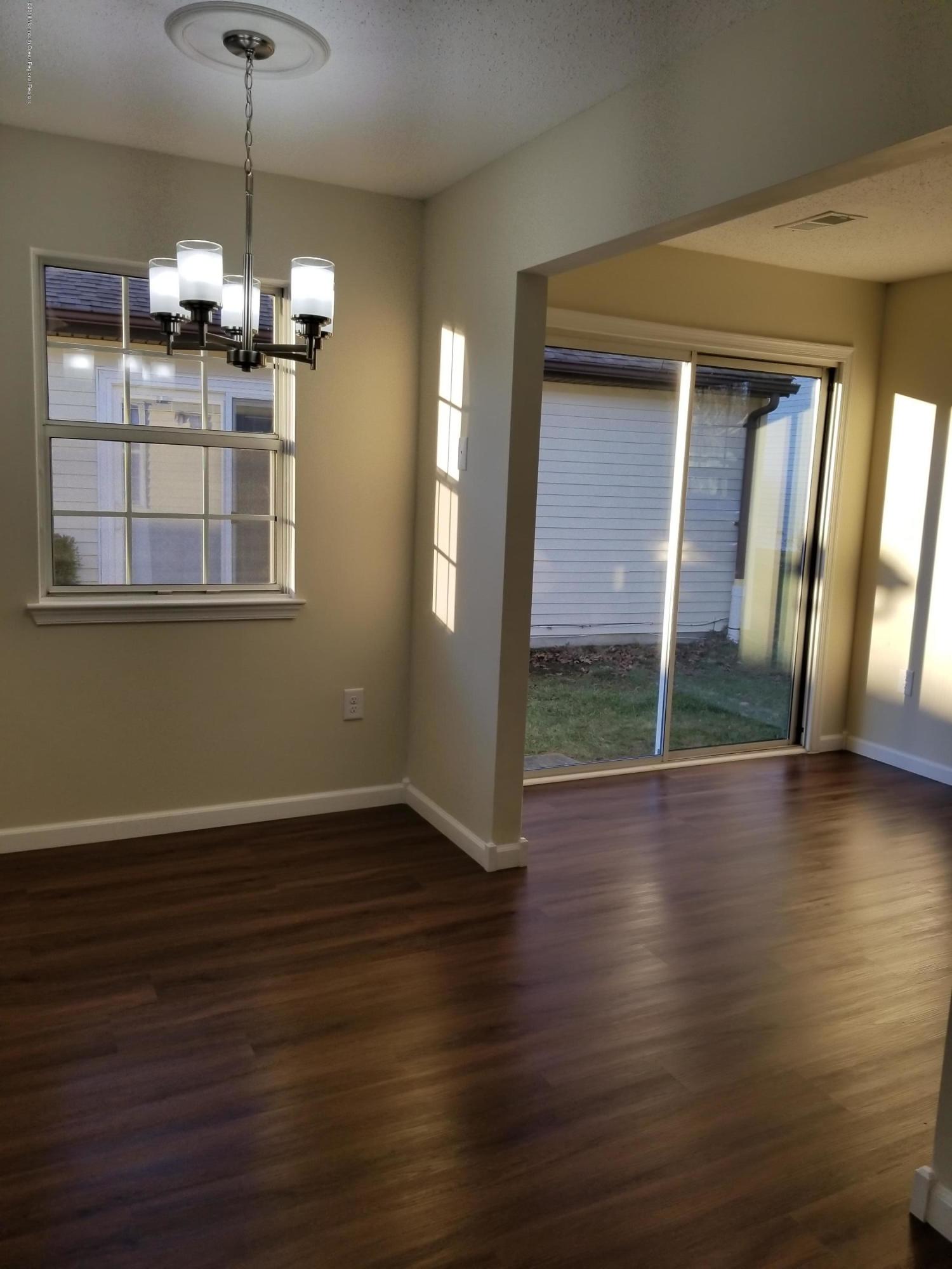 33 Ivy Ridge Close, Unit 1000 Freehold, NJ 07728 - Photo 10 of 31 a view of a room with wooden floor chandelier and windows