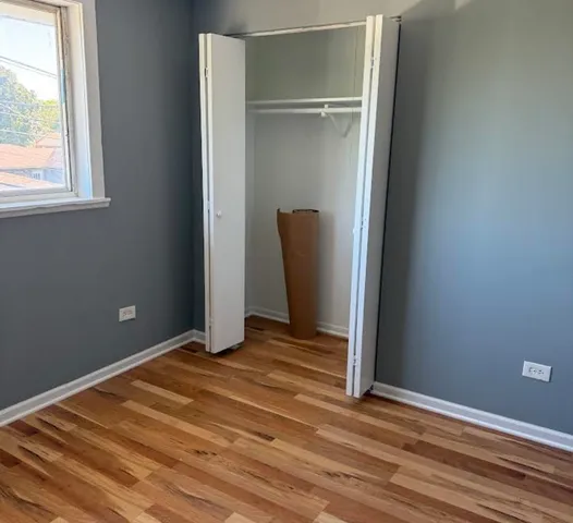 a view of a room with wooden floor and a window