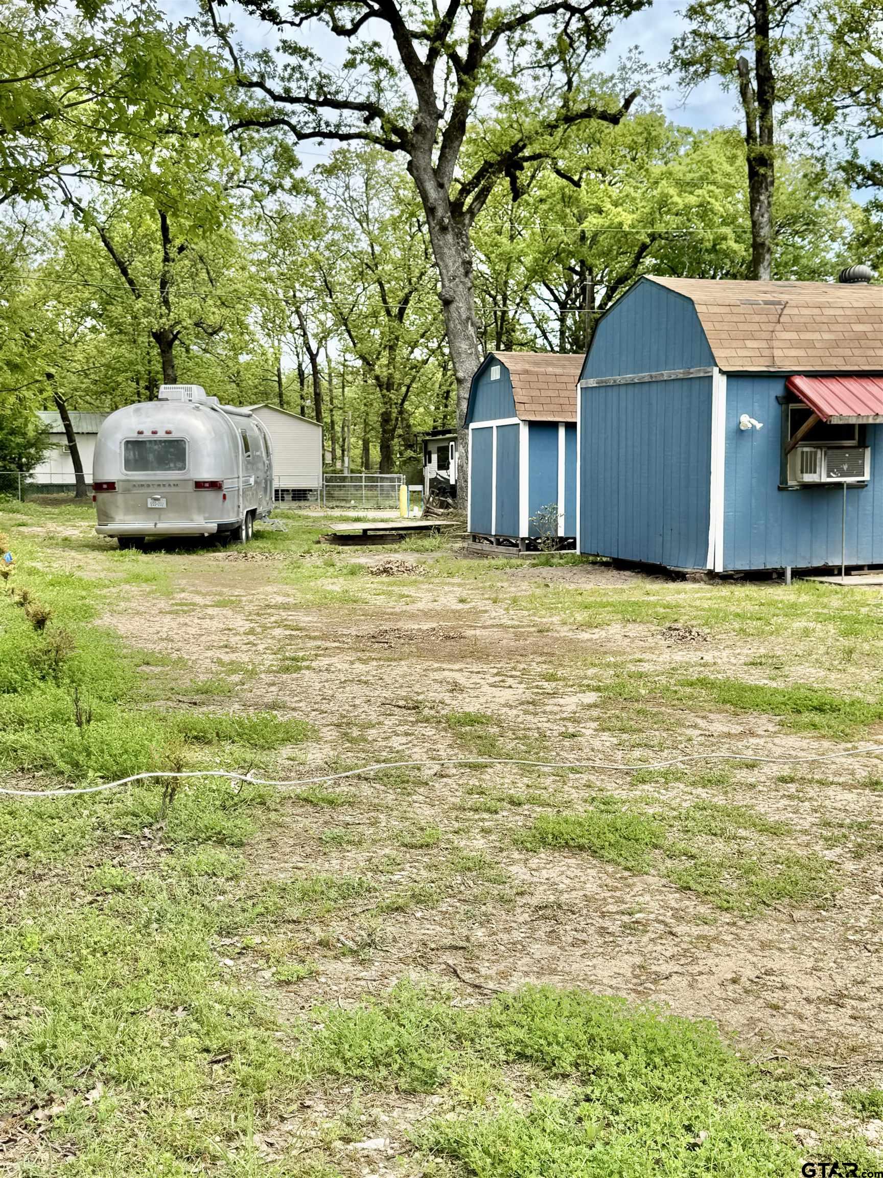 107 Private Road 7713 Emory, TX 75440 - Photo 6 of 22 a front view of a house with a yard and trees