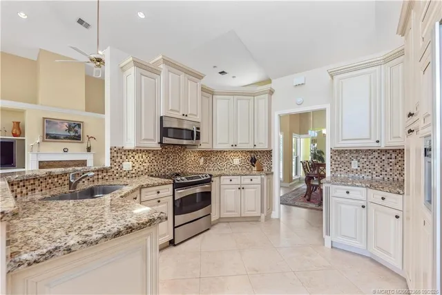 a kitchen with granite countertop a sink stove and cabinets