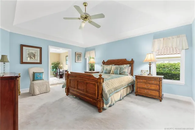 a spacious bedroom with a bed couch and windows