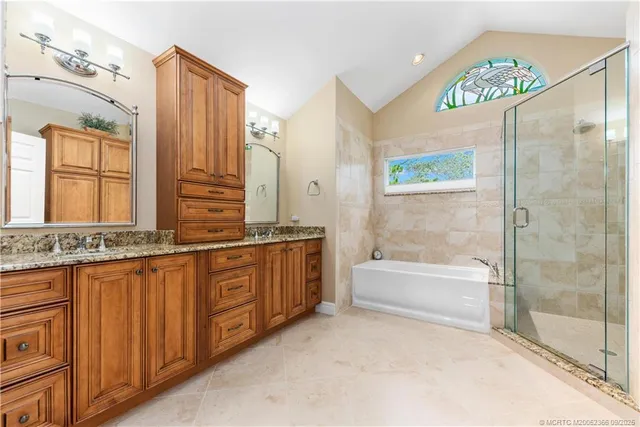 a bathroom with a tub a sink and a large mirror