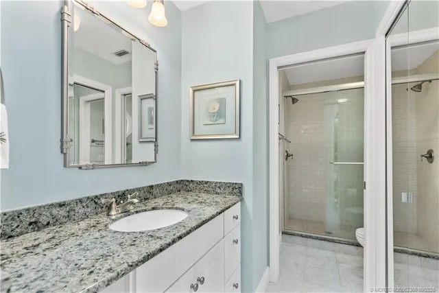a bathroom with a granite countertop sink and mirror