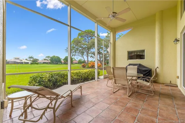 a view of a patio with a table chairs and a swimming pool