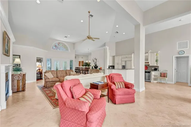 a living room with furniture kitchen view and a chandelier