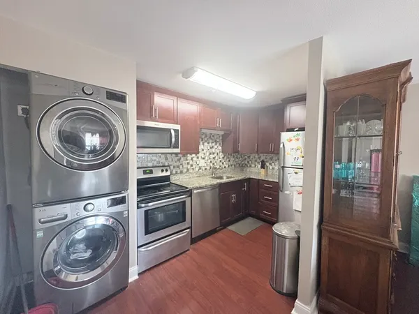 a kitchen with stainless steel appliances granite countertop a refrigerator and a sink