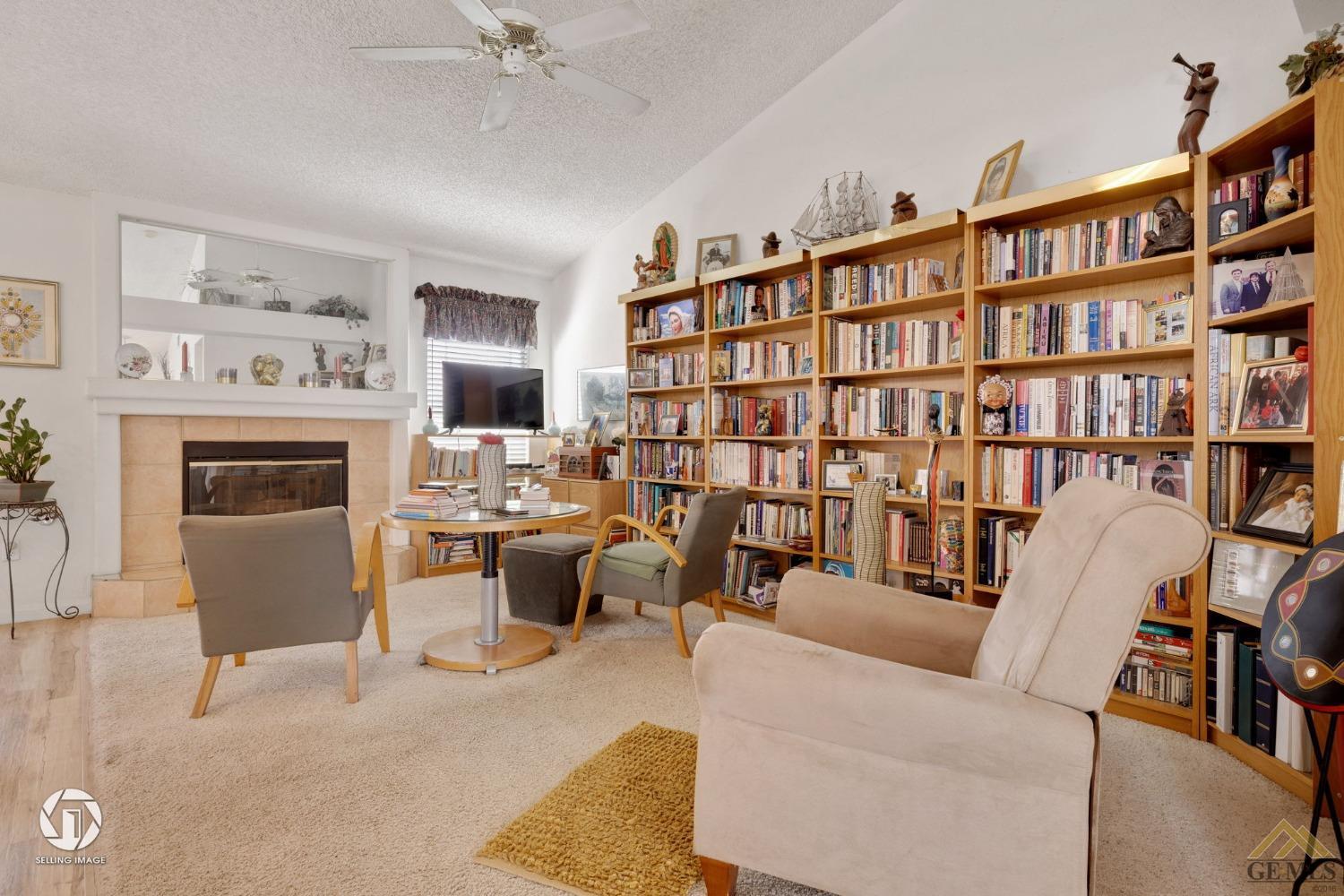 Undisclosed Address Bakersfield, CA 93312 - Photo 6 of 33 a living room with furniture a fireplace and a book shelf