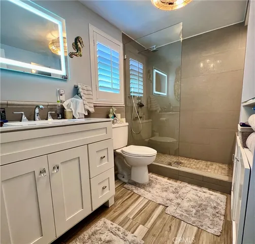 a bathroom with a sink a toilet and shower