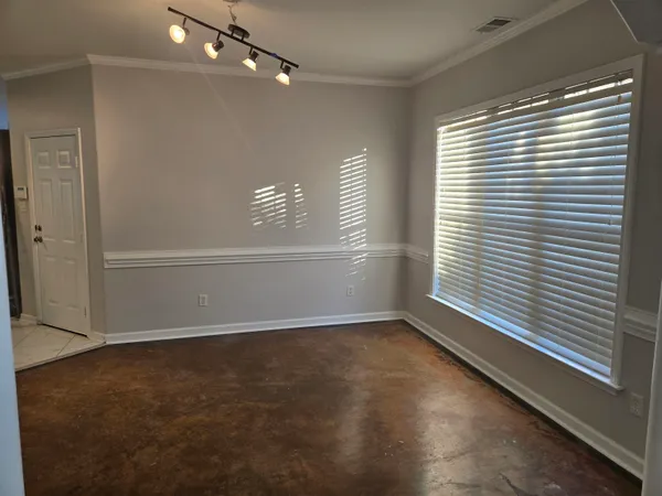 a view of an empty room with a chandelier fan
