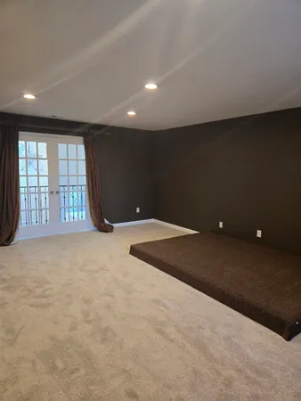 an empty room with windows and fireplace