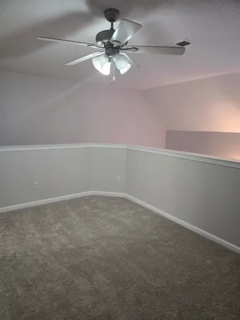 a view of a big room with windows and chandelier fan