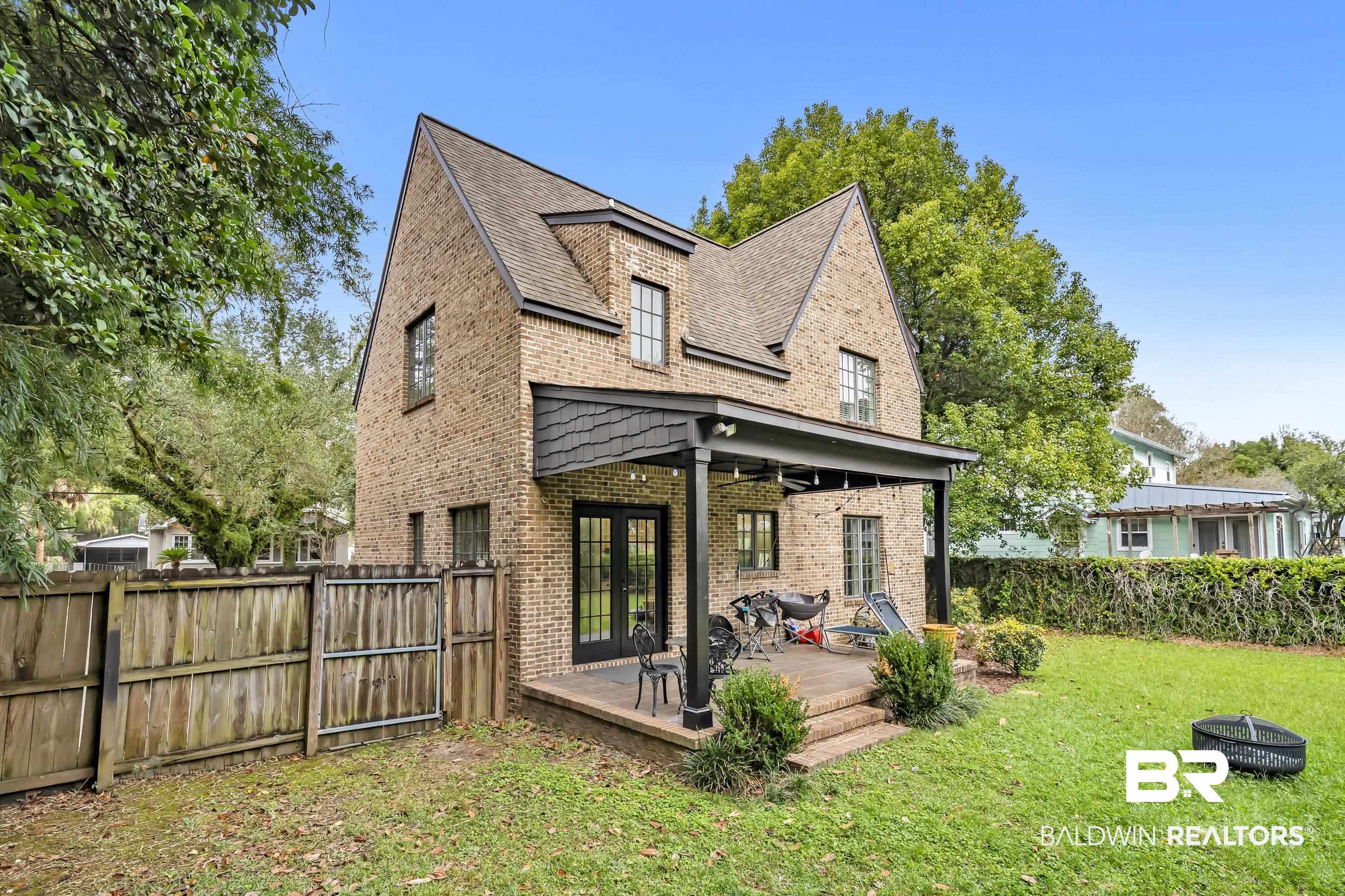 7 Bienville Avenue Mobile, AL 36606 - Photo 20 of 32 Back of house with a fenced backyard, an outdoor fire pit, brick siding, french doors, and a shingled roof