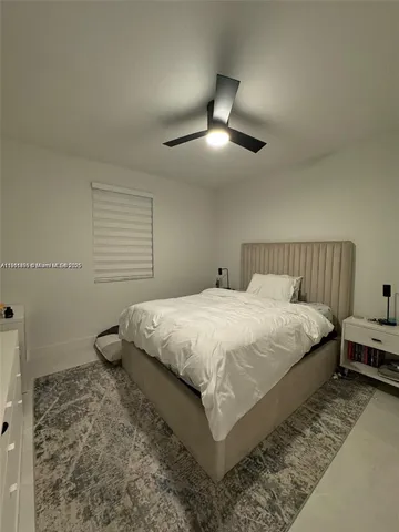 a bedroom with a bed and ceiling fan
