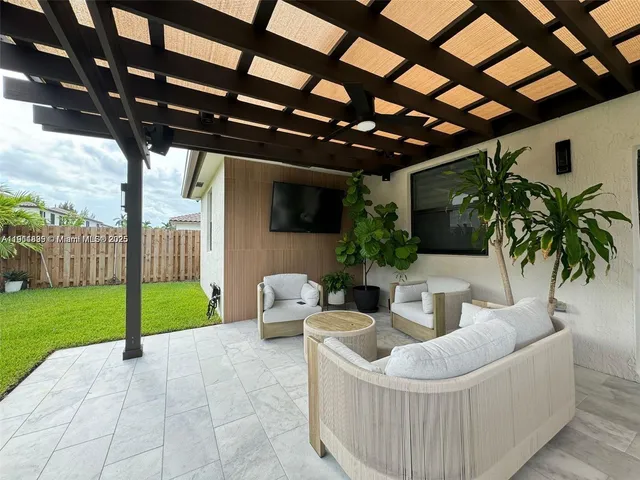 a living room with patio furniture and a garden