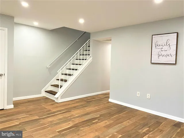 an empty room with wooden floor and white walls