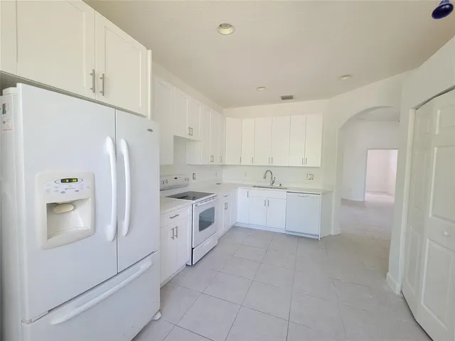 a kitchen with white cabinets and white appliances