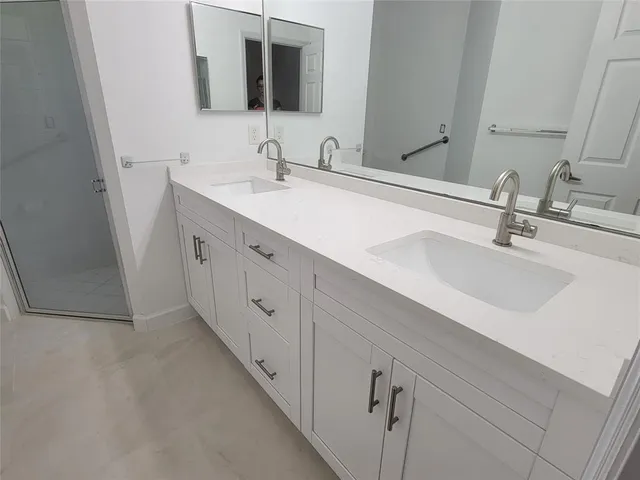 a bathroom with a double vanity sink and mirror