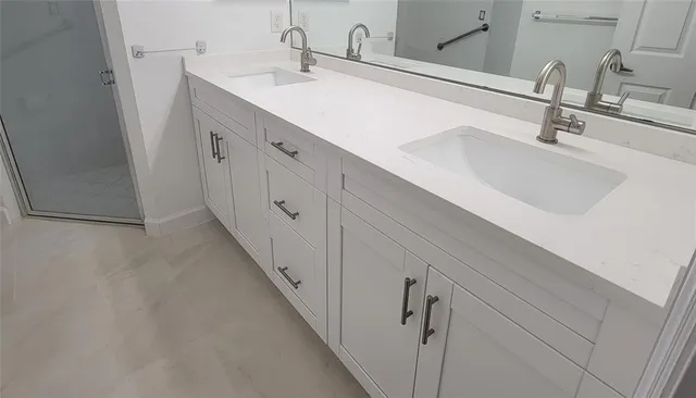 a bathroom with double vanity sink and mirror