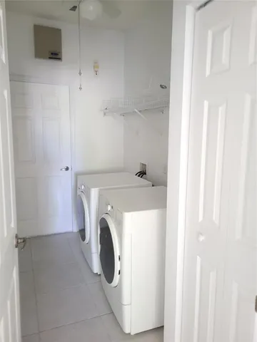 a front view of a house with garden and a tree