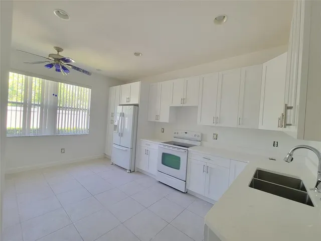 a kitchen with white cabinets and white appliances