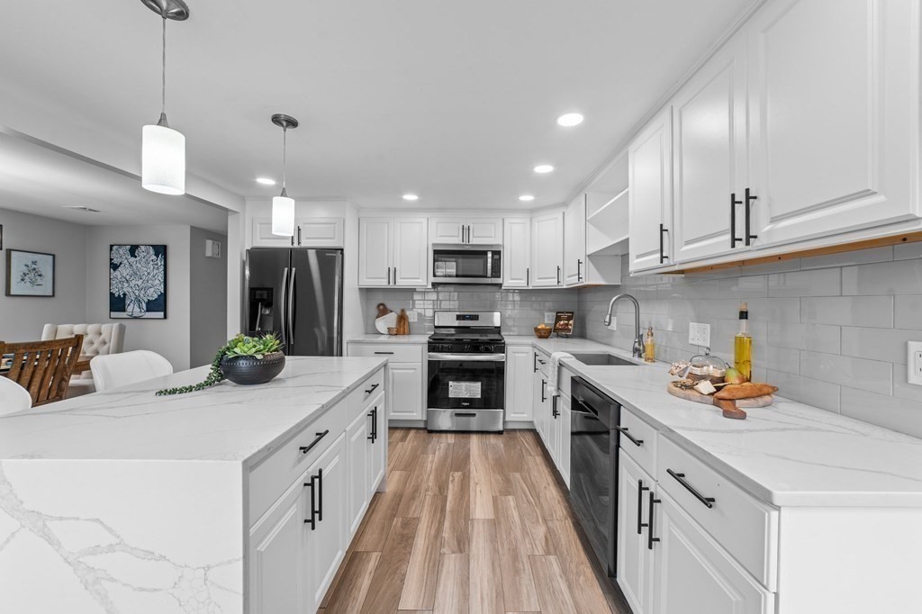 38 Wayside Lane Ashland, MA 01721 - Photo 12 of 40 a kitchen with stainless steel appliances kitchen island granite countertop a sink a stove and cabinets