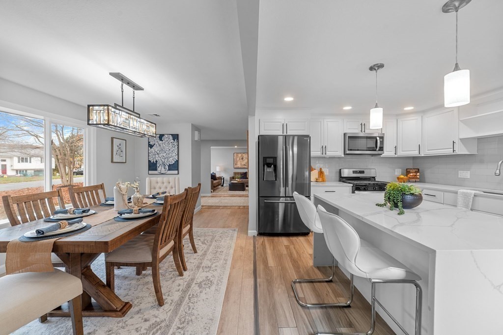 38 Wayside Lane Ashland, MA 01721 - Photo 9 of 40 a kitchen with stainless steel appliances kitchen island granite countertop a dining table chairs and white cabinets
