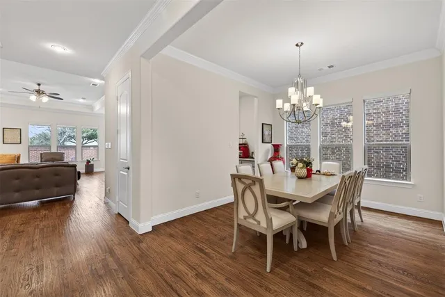 a view of a dining room with furniture a chandelier and wooden floor