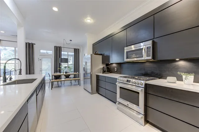 a kitchen with stainless steel appliances granite countertop a sink stove and cabinets