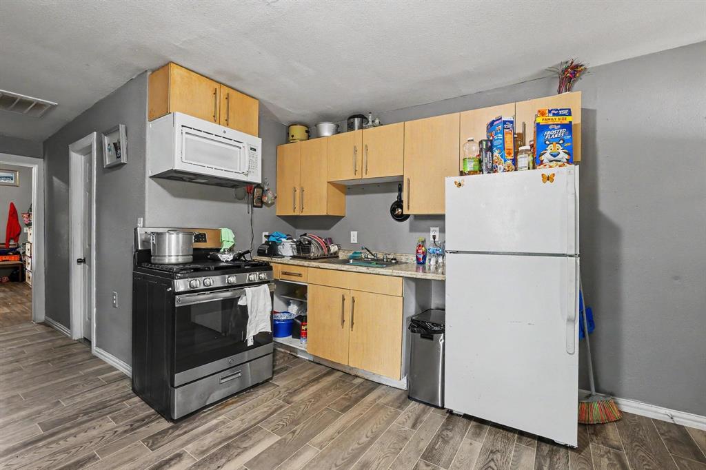 205 South Main Street Bonham, TX 75418 - Photo 12 of 23 a kitchen with stainless steel appliances granite countertop a refrigerator stove a sink and dishwasher
