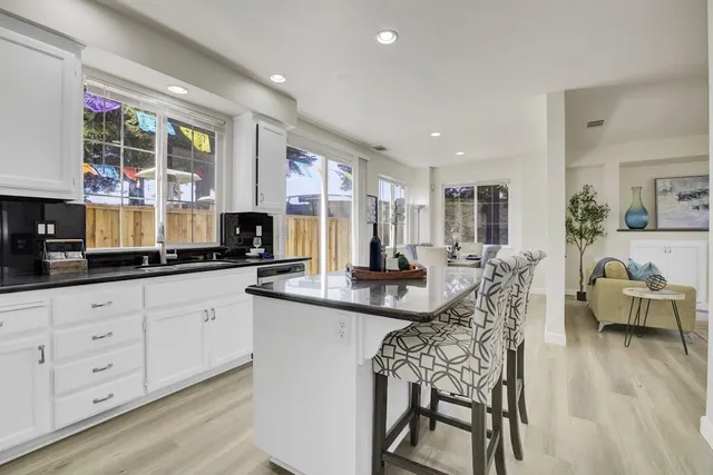 a kitchen with white cabinets and chairs