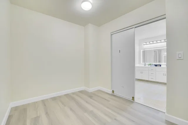a view of empty room with wooden floor and cabinet