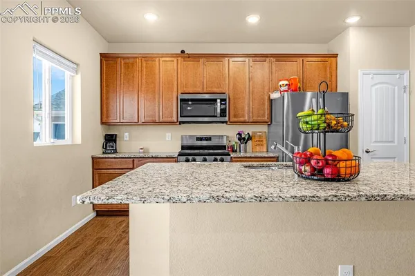 a kitchen with stainless steel appliances granite countertop a stove a sink and a refrigerator