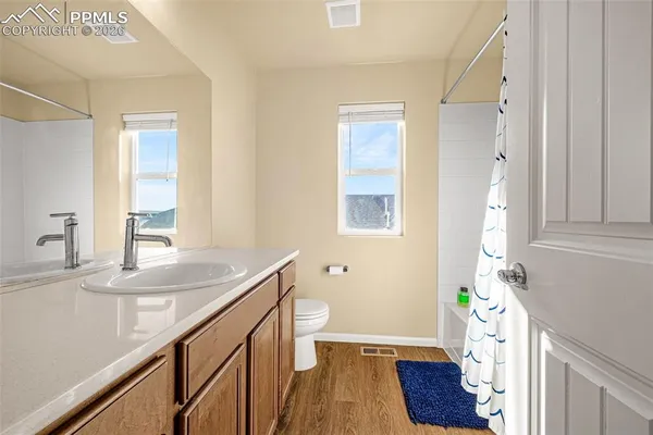 a bathroom with a sink a toilet and a window