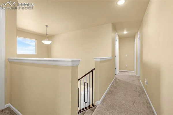 a view of a hallway with wooden floor and staircase