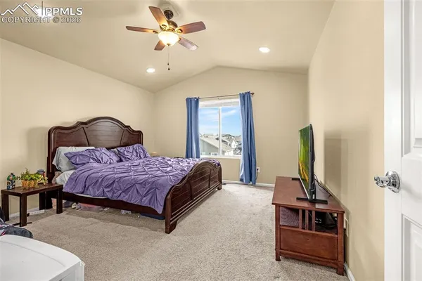 a bedroom with a bed a chandelier and dresser