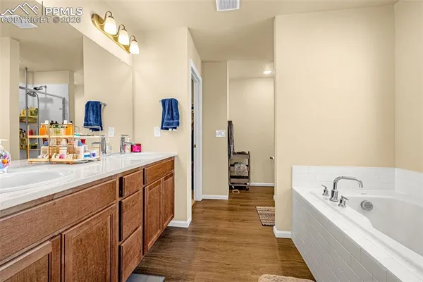 a bathroom with a tub sink and mirror
