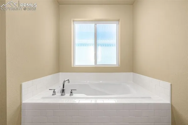 a bathroom with bathtub and window