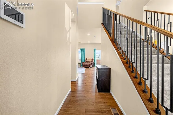 a view of a hallway with wooden floor and staircase
