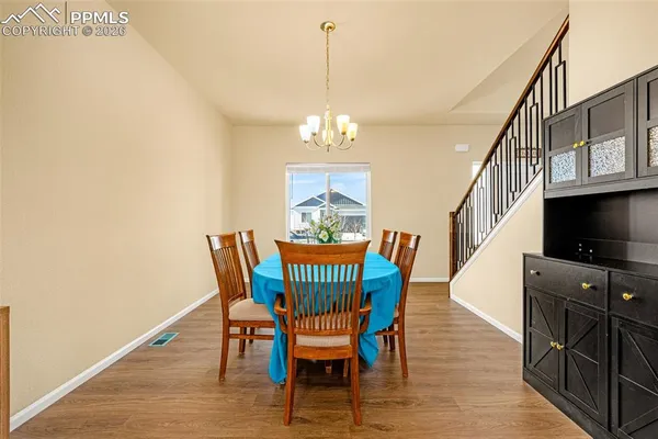 a view of a dining room with furniture a chandelier and wooden floor