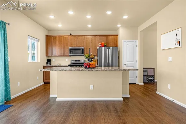 a kitchen with wooden floors and wooden cabinets